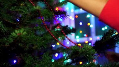 Noel ağacı Noel ile dekorasyon el kadın parlayan ışıklar.