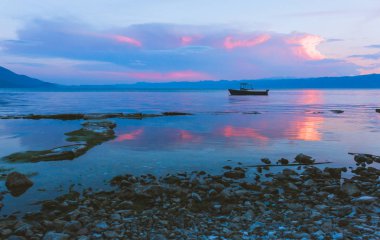 Gün batımı arka plan üzerinde tekne ile deniz manzarası