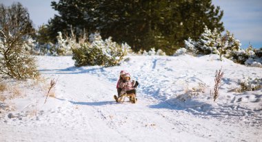 İki kız kardeş birlikte kış dağ tarafından sledging