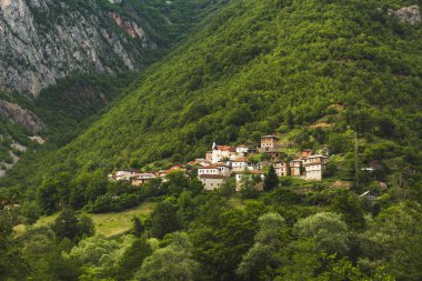 Dağlar yeşil ağaçlar ve rahat gizli evleri ile kaplı 