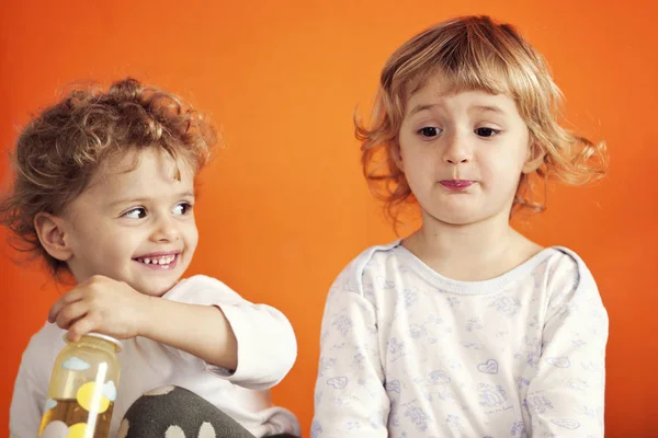 İki kız turuncu duvar arka plan üzerinde şaka