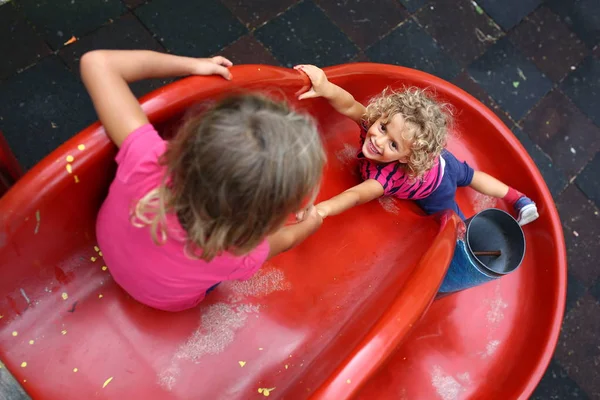 Birlikte oyun üzerinde kırmızı yamaç oynayan iki güzel kızlar