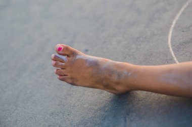 Kız kirli bacak görünümünü asfalt zemin üzerine kırpılmış