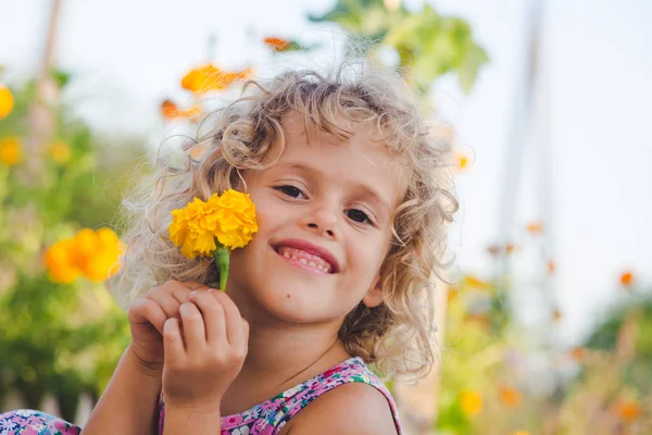 Portrét Úsměvem Kudrnatá Dívka Pózuje Žlutou Měsíček Květ — Stock fotografie