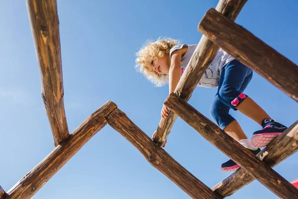 Ahşap günlükleri tırmanma sevimli kıvırcık kız