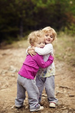 İki küçük çocuklar kız birlikte parkta yürüyüş