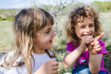 İki kız kardeş dışında kelebek ile oynarken