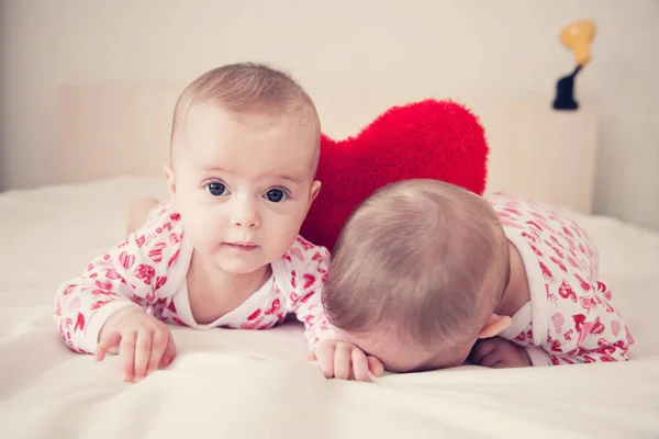 Due Bambine Sul Letto Con Cuscino Cuore — Foto Stock