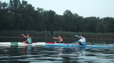 İyi koordine edilmiş ekip gölde kayak yapıyor.