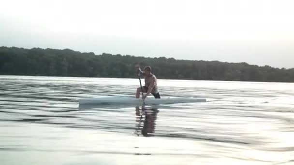 Joven remando en una canoa — Vídeo de stock