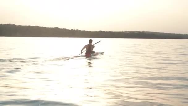 Joven remando un kayak — Vídeo de stock
