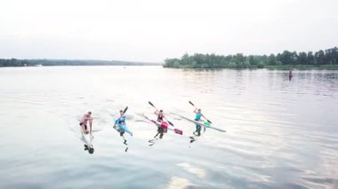 İyi koordine edilmiş ekip gölde kayak yapıyor.
