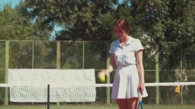 Kadın tenisçi sahada vuruş pratiği yapıyor.