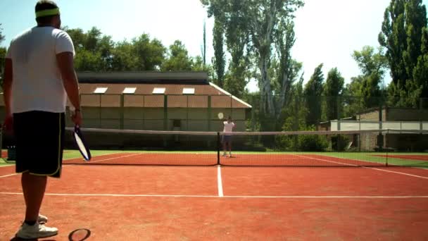 Anonym män som spelar tennis på banan på sommaren — Stockvideo