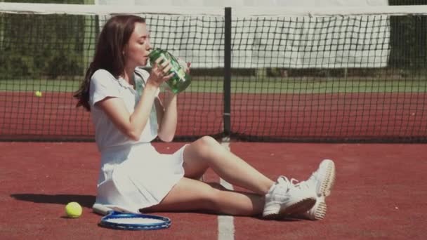 Kvinnlig tennisspelare dricksvatten under pausen — Stockvideo