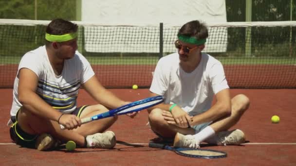 Jugadores de tenis alegres hablando durante el descanso — Vídeo de stock