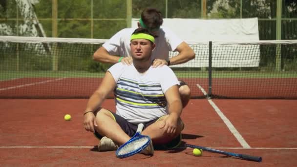 Tränare masserar axlar av fyllig tennisspelare — Stockvideo