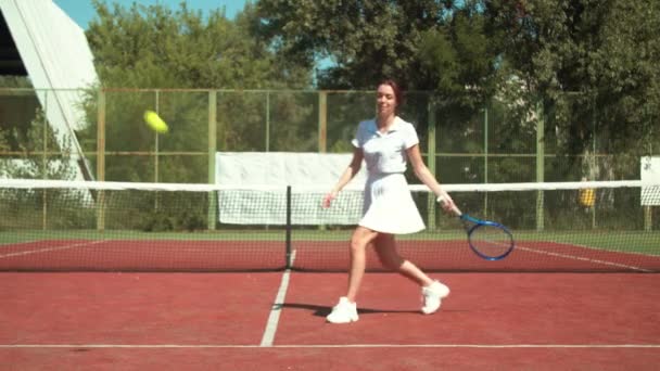 Deportista feliz aprendiendo a jugar al tenis en la cancha — Vídeo de stock