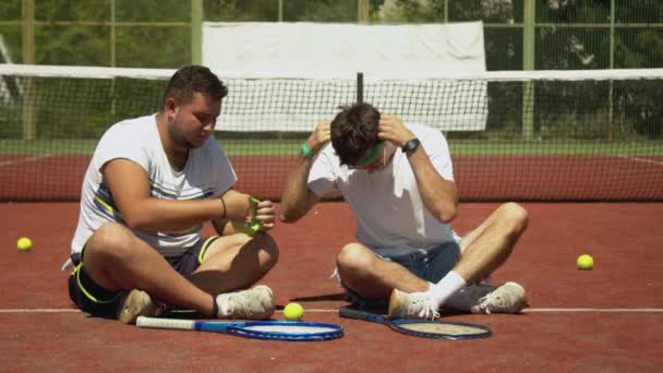 Jugadores de tenis alegres hablando durante el descanso — Vídeo de stock
