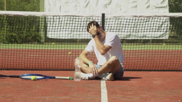 Jogador de tênis descansando perto da rede na quadra — Vídeo de Stock