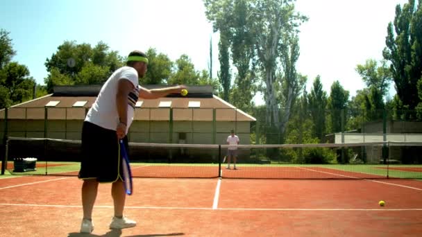 Hombres anónimos jugando al tenis en la cancha en verano — Vídeo de stock