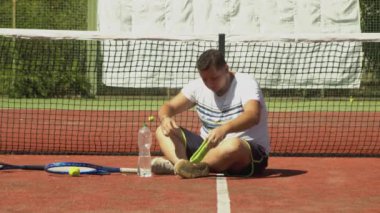 Tenis oyuncusu teneffüste su içiyor.
