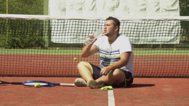 Jugador de tenis regordete beber agua durante el descanso — Vídeo de stock
