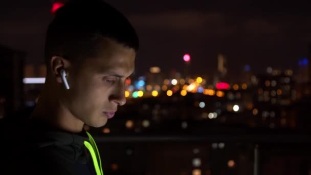 Junger Mann hört nachts Musik — Stockvideo