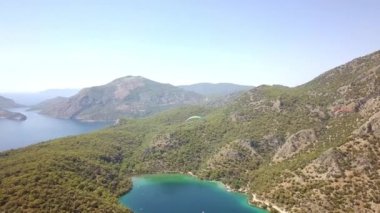 Paragliderler tatil köyünde deniz ve sahil üzerinde uçuyorlar.