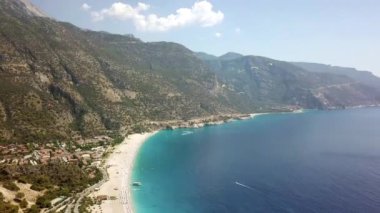 Paragliderler tatil köyünde deniz ve sahil üzerinde uçuyorlar.
