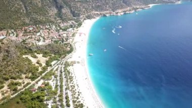 Paragliderler tatil köyünde deniz ve sahil üzerinde uçuyorlar.