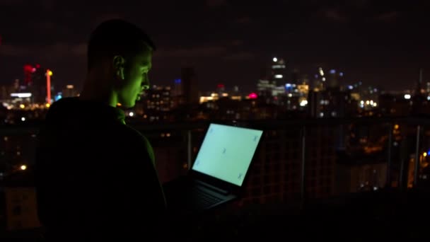 Hombre usando el ordenador portátil y hablando por la noche — Vídeos de Stock