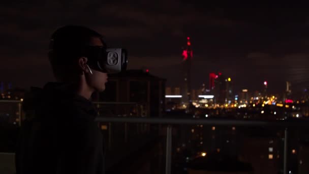 Joven explorando la realidad virtual por la noche — Vídeos de Stock