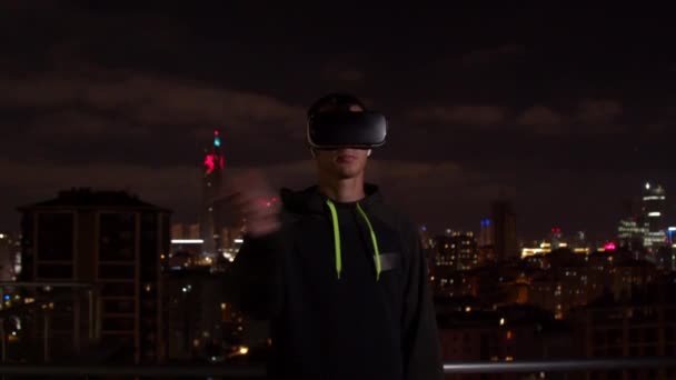 Genç adam geceleri sanal gerçekliği keşfediyor. — Stok video