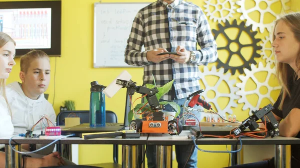 Unrecognizable students assembling car in robotics class — Stock Photo, Image