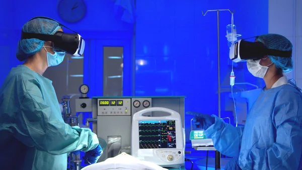 Médicos en gafas VR realizando cirugía en el hospital —  Fotos de Stock