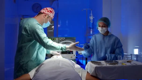 Хирург делает операцию в операционной в больнице — стоковое видео