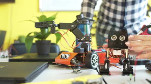 Teenage boy playing with robot in class — Stock video