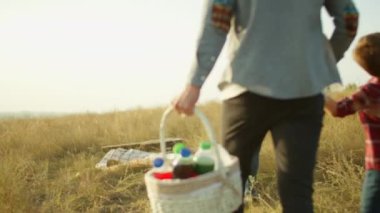 Aile piknik sırasında battaniyeye oturur.