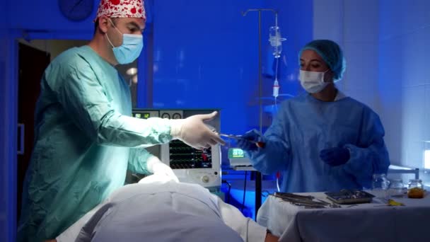 Хірург робить операцію в операційній кімнаті в лікарні — стокове відео