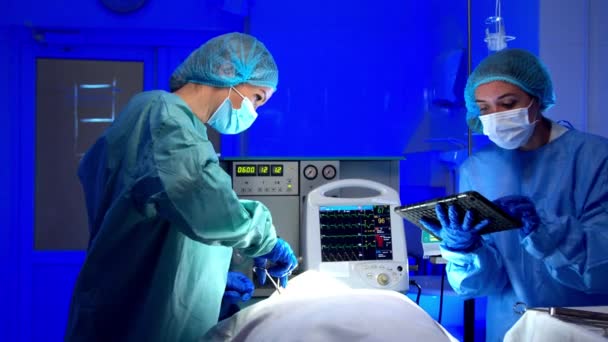 Жіночі медики, що виконують операцію в операційному театрі — стокове відео