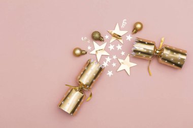 Noel kraker. pastel pembe bir arka plan üzerinde lüks altın şenlikli kraker