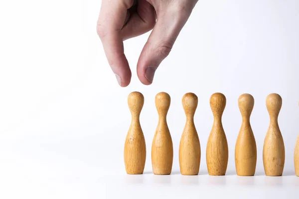 Hand selecting a wooden figure. Business leadership concept