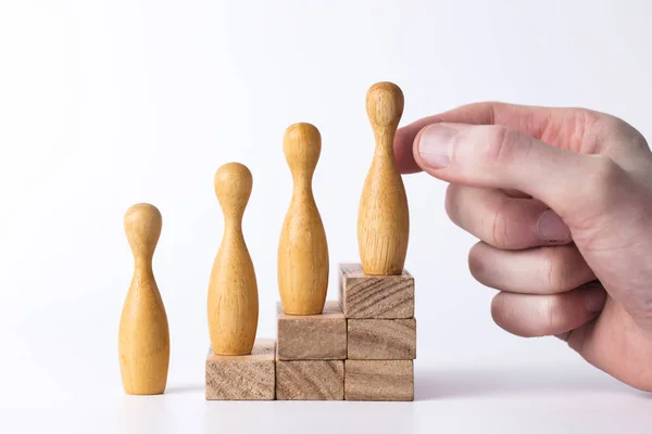 Hand selecting a wooden figure. Business leadership concept