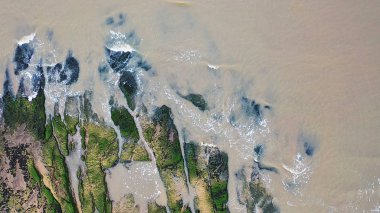 Okyanus dalgaları karşı yeşil yosun kaplı taş kırma sakin hava havai görünümü