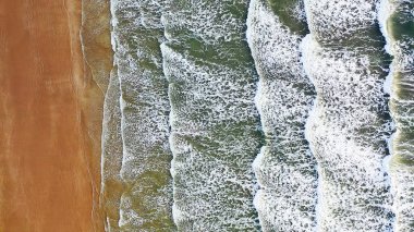 Deniz ve plaj havadan görünümü. Kumlu beac karşı köpük dalgalar gürültüyle çarpmak