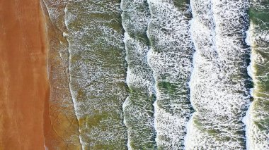 Deniz ve plaj havadan görünümü. Kumlu beac karşı köpük dalgalar gürültüyle çarpmak