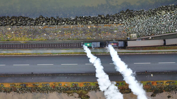 Aerial view of a vintage steam engine train with puffing smoke