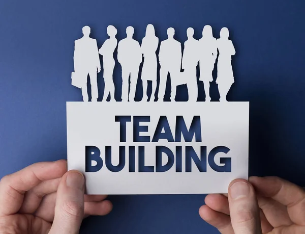 Manos sosteniendo un cartel blanco de gente de negocios de team building . — Foto de Stock