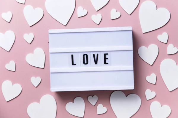 Láska lightbox zpráva s bílým srdcem na růžovém pozadí — Stock fotografie